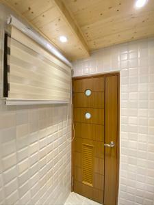 a walk in shower with a wooden door in a room at Sugar 5 in Jian