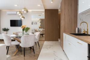 cocina y comedor con mesa y sillas en GA Luxury Apartments G9, en Cracovia