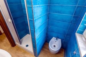 uma casa de banho com azulejos azuis e um WC. em Villaggio Residence Torre Saracena em Marina di Camerota
