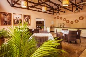 a dining room with tables and chairs and plants at Bushveld Terrace Safari Hotel, Lodge & Spa in Phalaborwa