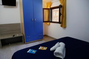 een slaapkamer met een blauw bed en een blauwe kast bij Villaggio Residence Torre Saracena in Marina di Camerota