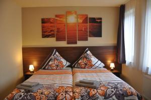 a bedroom with a bed with two lamps and two pictures at Ursprung Apartments in Rostock