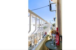 un balcón con una mesa y copas de vino. en Chic Suite Figueiras w balcony in Taviras Historical Centre, en Tavira