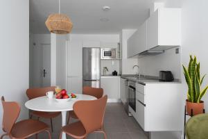 a kitchen with a white table and chairs in a room at Royal Flats in Las Palmas de Gran Canaria