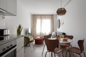 a kitchen and living room with a table and chairs at Royal Flats in Las Palmas de Gran Canaria
