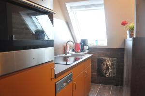 
a kitchen with a stove and a microwave at Ursprung Apartments in Rostock

