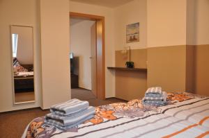 a bedroom with a bed with towels on it at Ursprung Apartments in Rostock