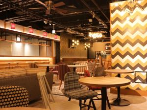 a restaurant with tables and chairs in a room at UMEDAHOLIC HOTEL in Osaka