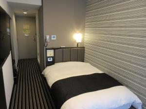 a hotel room with a bed in a room at APA Hotel Utsunomiya-Ekimae in Utsunomiya