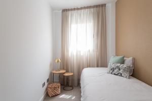 a bedroom with a white bed and a window at Royal Flats in Las Palmas de Gran Canaria