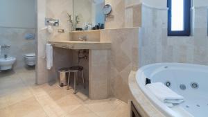 a bathroom with a tub and a sink and a toilet at SH Villa Gadea in Altea