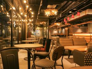 a restaurant with tables and chairs and chandeliers at UMEDAHOLIC HOTEL in Osaka +36 photos