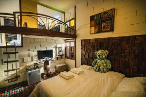 Suankaew​ art​ hostel​ في شون بوري: غرفة نوم مع دمية الدب يجلس على سرير