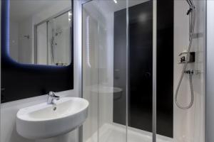 a bathroom with a shower, sink, and toilet at Kip Hotel in London