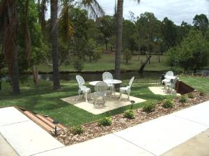 eine Terrasse mit einem Tisch und Stühlen in einem Park in der Unterkunft Park House Motor Inn in Oakey