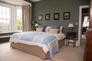 una camera da letto con un letto grande con lenzuola blu e bianche di The Manor House at Boconnion a Bodmin