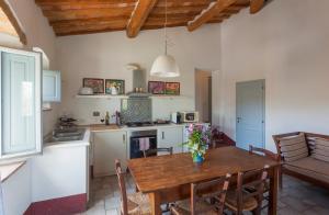a kitchen and dining room with a wooden table at Poderi in Chianti in Tavarnelle in Val di Pesa