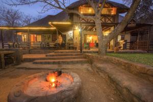 a fire pit in front of a house at Khaya Umdani Guest Houses in Marloth Park