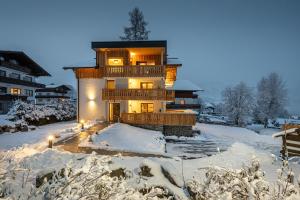 een huis in de sneeuw met lichten aan bij sWiederkehr in Schladming