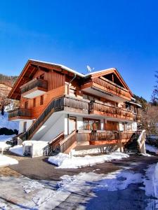 a large wooden house with decks in the snow at Residence Margerithenweg in Bad Kleinkirchheim