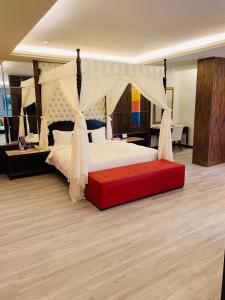 1 dormitorio con 1 cama grande y banco rojo en Merryseasons, en Kaohsiung