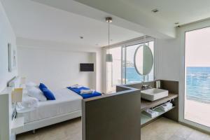 a bathroom with a bed and a sink and a mirror at Hotel Maritim in Roses