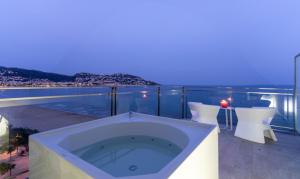 a bath tub on a balcony with a view of the water at Hotel Maritim in Roses