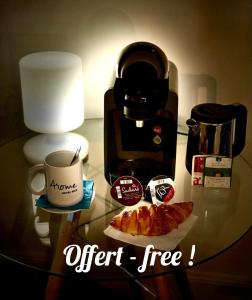 Arome Hotel في نيس: طاولة مع آلة صنع القهوة وكوب من القهوة