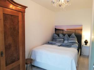 a bedroom with a white bed with striped pillows at FeWo Segelwind in Bodman-Ludwigshafen