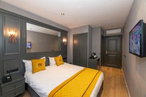 een slaapkamer met een groot bed met twee gele kussens bij Peri Hotel Taksim in Istanbul