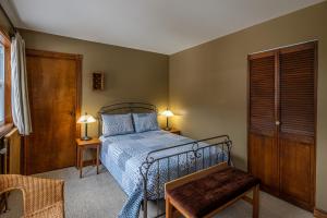 a bedroom with a bed with a blue comforter at Manoir D'Orsennens in Lac-Mégantic