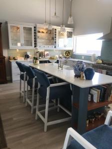 a kitchen with a large white island with blue chairs at Chartwell House in Velddrif