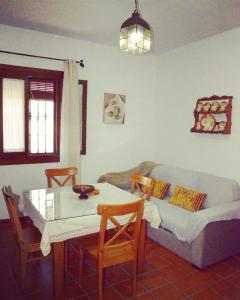 sala de estar con mesa y sofá en Casa Rural Aya II, en Linares de la Sierra