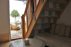 a living room with a staircase with a table at Riad El Ouarda in Marrakesh