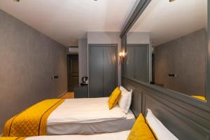 a bedroom with a large bed with yellow pillows at Peri Hotel Taksim in Istanbul