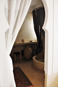 - une vue sur la salle de bains pourvue d'un rideau de douche dans l'établissement Riad El Ouarda, à Marrakech