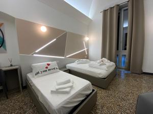 2 posti letto in una piccola stanza con un cartello sopra di Centro Acquario San Giorgio a Genova