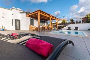 a chair with a red towel sitting next to a pool at Villa Kira, Tindaya in Tindaya