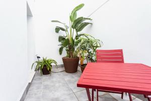 a red table and chair in a room with plants at Reina 107 Beach Boutique in Valencia