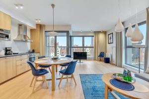 a kitchen and living room with a table and chairs at Granaria Comfort Apartments in Gdańsk