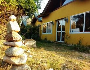 a stack of rocks in front of a yellow house at El Mundo Interior in Capilla del Monte