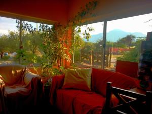 a living room with a red couch and a large window at El Mundo Interior in Capilla del Monte