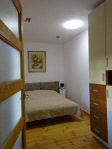 1 dormitorio con 1 cama y suelo de madera en Apartamenty w Ustce en Ustka