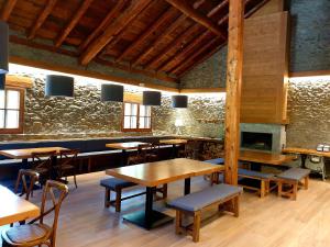 um restaurante com mesas e cadeiras de madeira e uma lareira em Bungalows Nou Camping em Guingueta