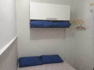 Habitación pequeña con 2 almohadas azules en un estante en Copacabana Flat, en Río de Janeiro