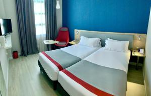 
a hotel room with a bed and a dresser at Holiday Inn Express Ciudad de las Ciencias, an IHG Hotel in Valencia

