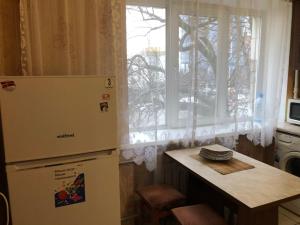 キーウにあるKyiv Apartment on Peremohy Avenue 16 daily rentのキッチン(冷蔵庫、テーブル付)、窓が備わります。