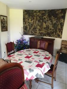 ein Esszimmer mit einem Tisch und einem Weihnachtsbaum in der Unterkunft LE GITE DU COLOMBIER in Bracquetuit