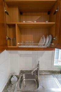 a kitchen with a sink and a shelf with dishes at Studio near the Sea and City in Las Palmas de Gran Canaria