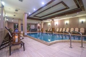 una piscina in un hotel con sedie e una camera di Maria-Antoaneta Residence a Bansko